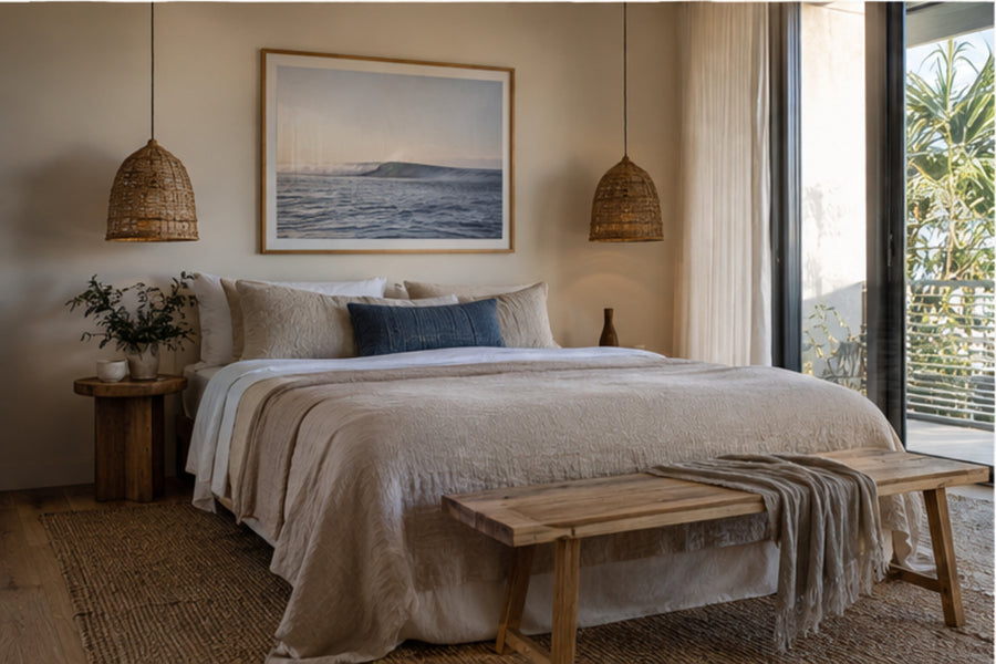 Boutique coastal hotel bedroom with framed ocean artwork