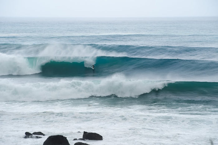Surfer riding a left-hand point break in England, photographed by Devon-based surf photographer Christian Jones.