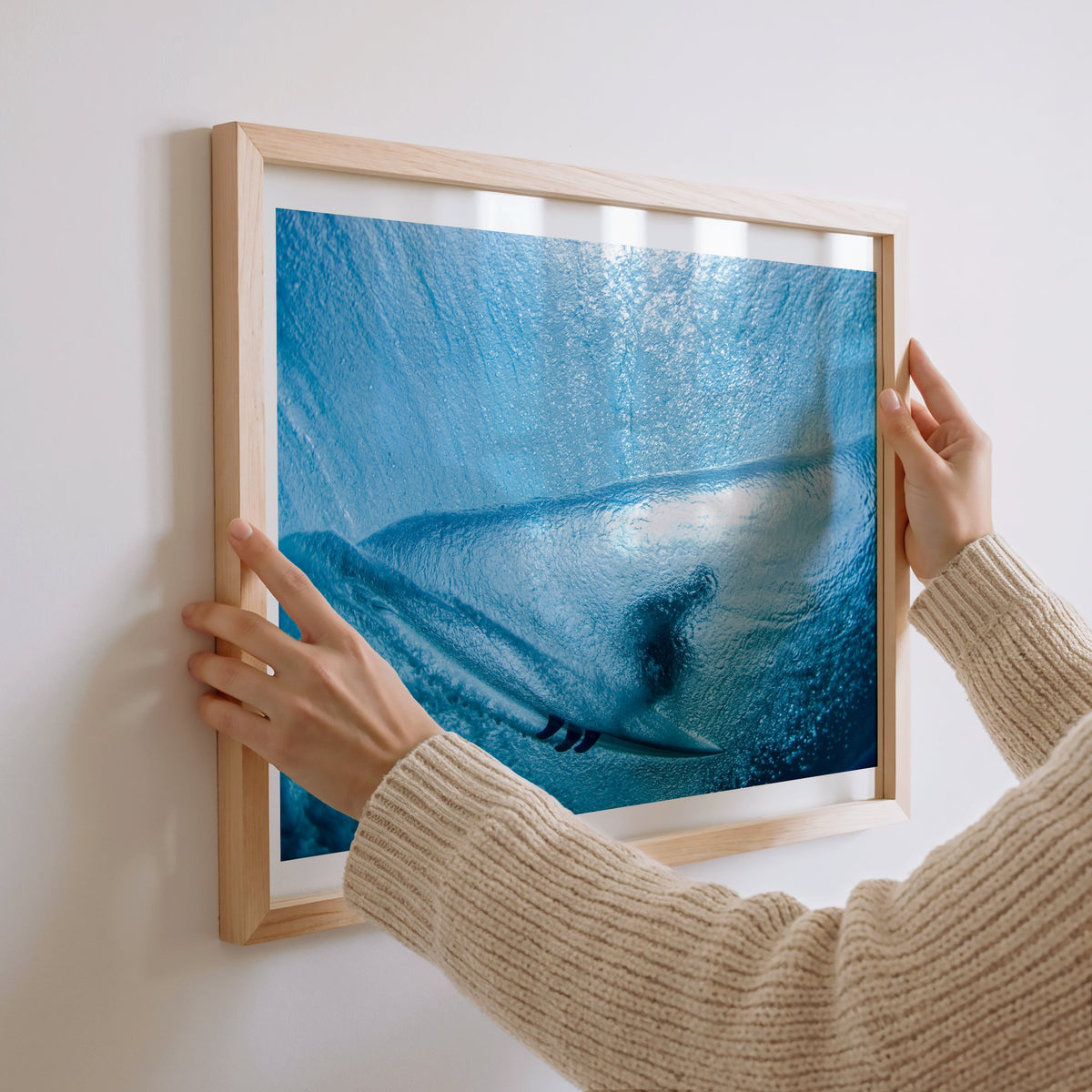 Aqua Cocoon surf photography print with a white border by Sean Davey being hung on a wall