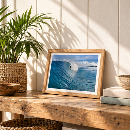 Small Blue Sling surf photography print with a white border by Sean Davey in a small frame on a wooden bench with plants