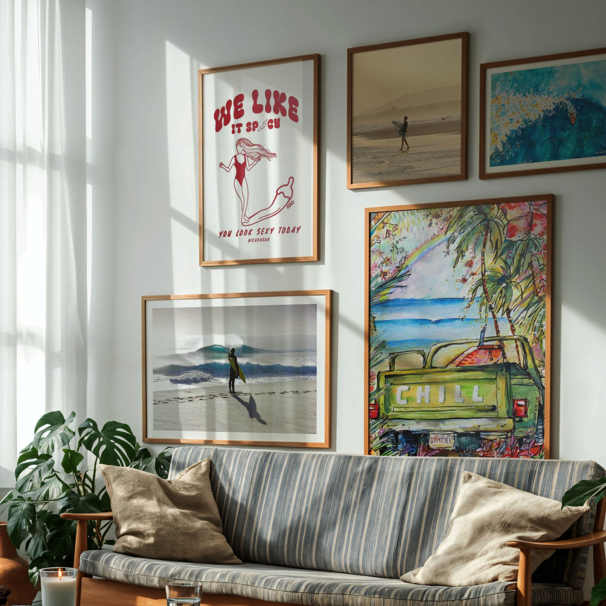 Three oak-framed surf art prints on a sunlit wall above a wooden sideboard, with a surfboard leaning alongside