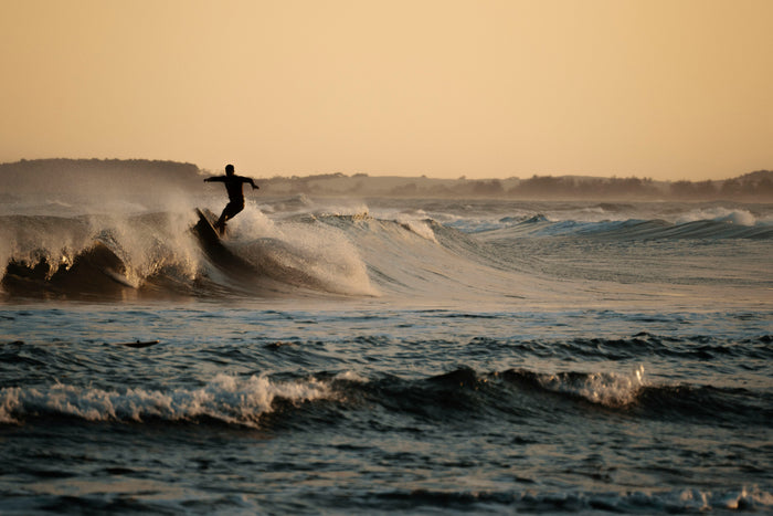 Silhouetted surfer launching off the lip at sunset, Brazil, surf photograph by Douglas Schneiders
