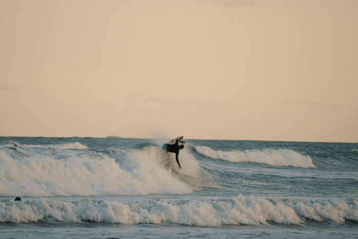 Surfer hitting a backside top turn at golden hour, Praia da Vila, Brazil