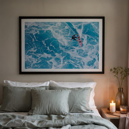 Marble Carve surf photography print with a white border by Sean Davey in a black frame above a bed