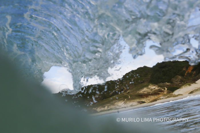 View from inside the barrel looking out to the beach, in-water photograph by Murilo Lima