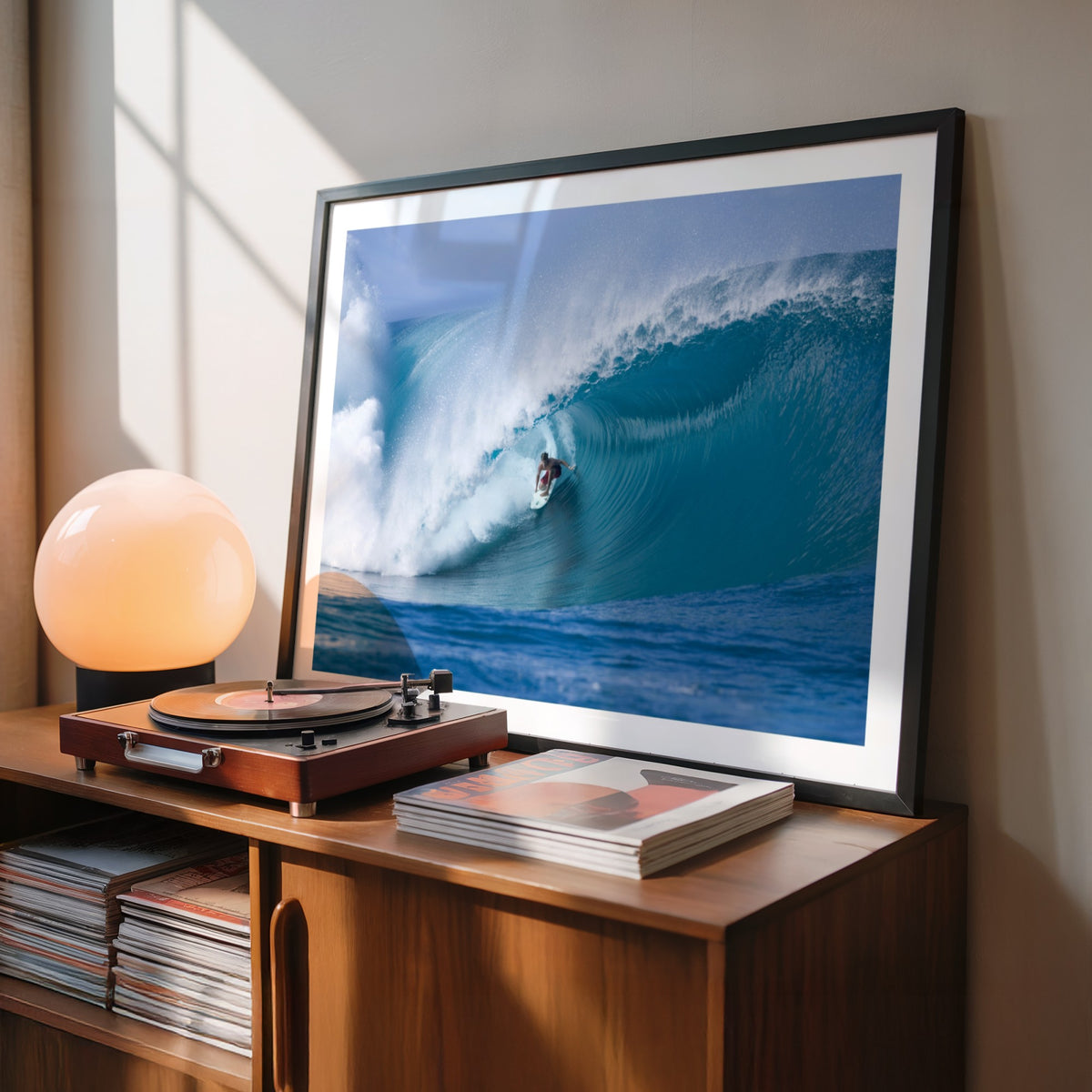 Perfection surf photography print by Sean Davey in a black frame beside a record player