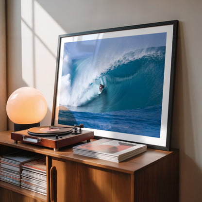 Perfection surf photography print by Sean Davey in a black frame beside a record player