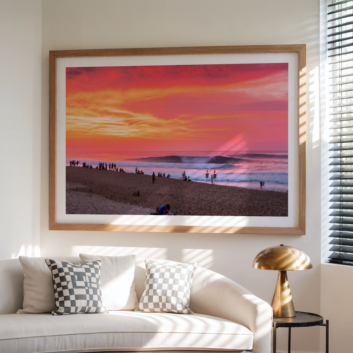 Pipeadelic surf photography print with a white border by Sean Davey framed above a sofa beside a lamp