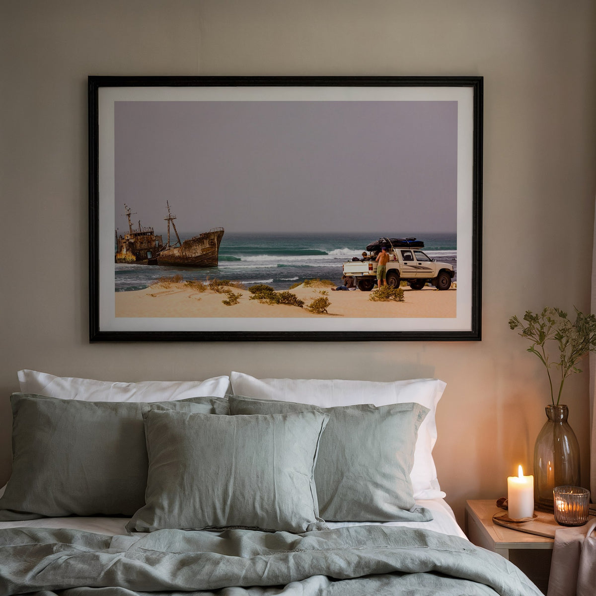 Shipwrecks surf photography print with a white border by John Seaton Callahan in a black frame above a bed