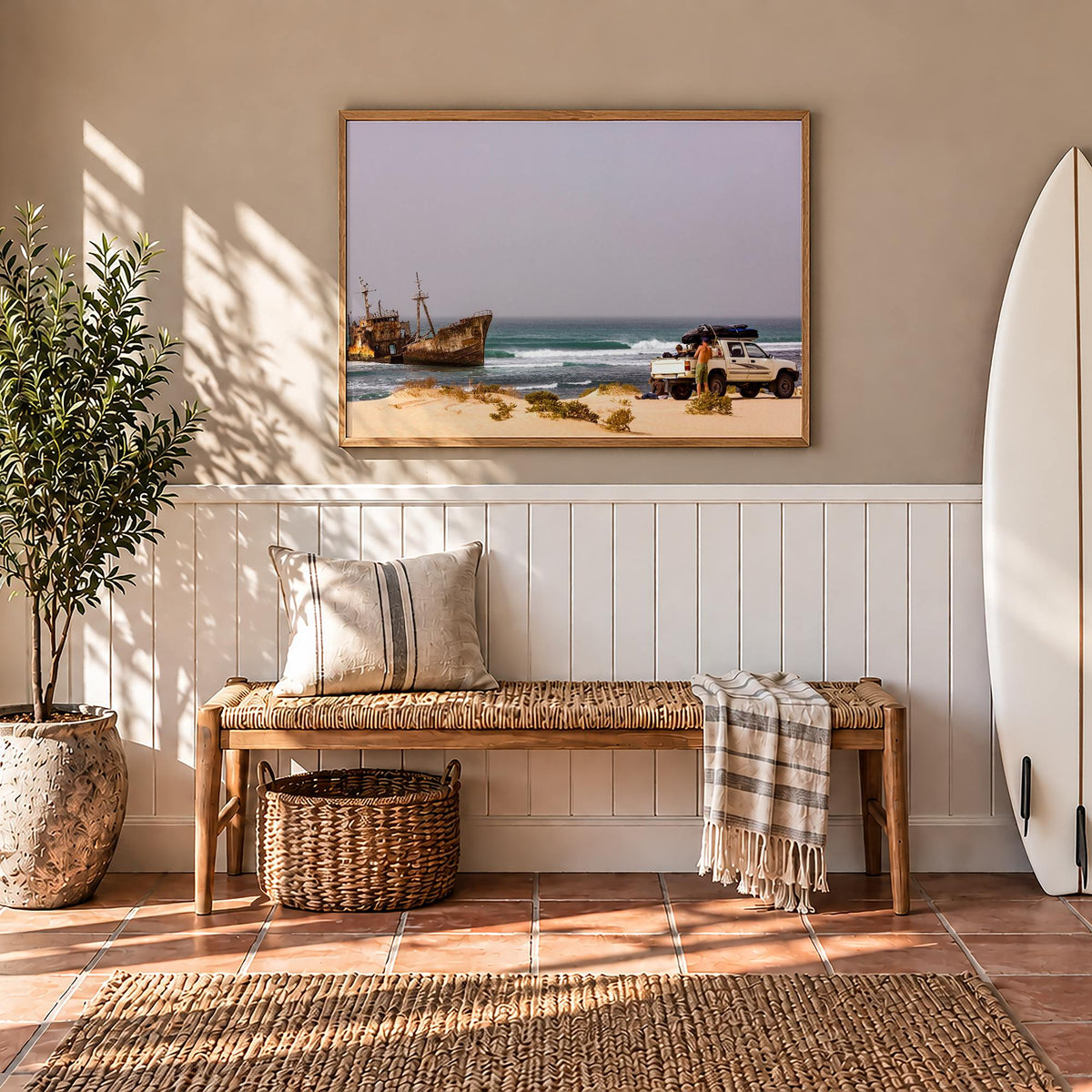 Shipwrecks surf photography print by John Seaton Callahan framed in a hallway above a bench, beside a surfboard