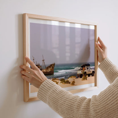 Shipwrecks surf photography print with a white border by John Seaton Callahan being hung on a wall