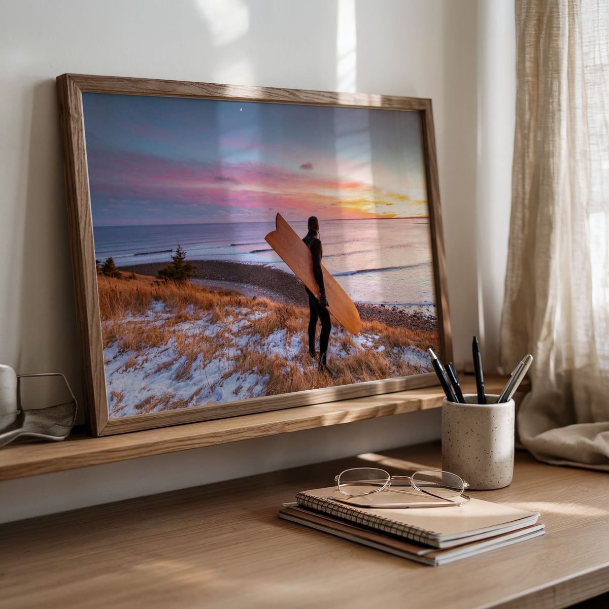 Snow and Sunrise winter surf photography print by Adam Cornick framed and leaning on a desk
