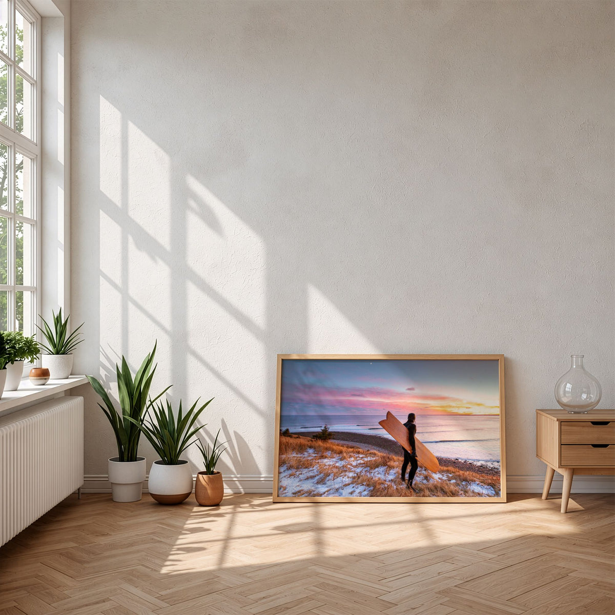 Snow and Sunrise winter surf photography print by Adam Cornick framed and leaning on the floor in morning sunlight