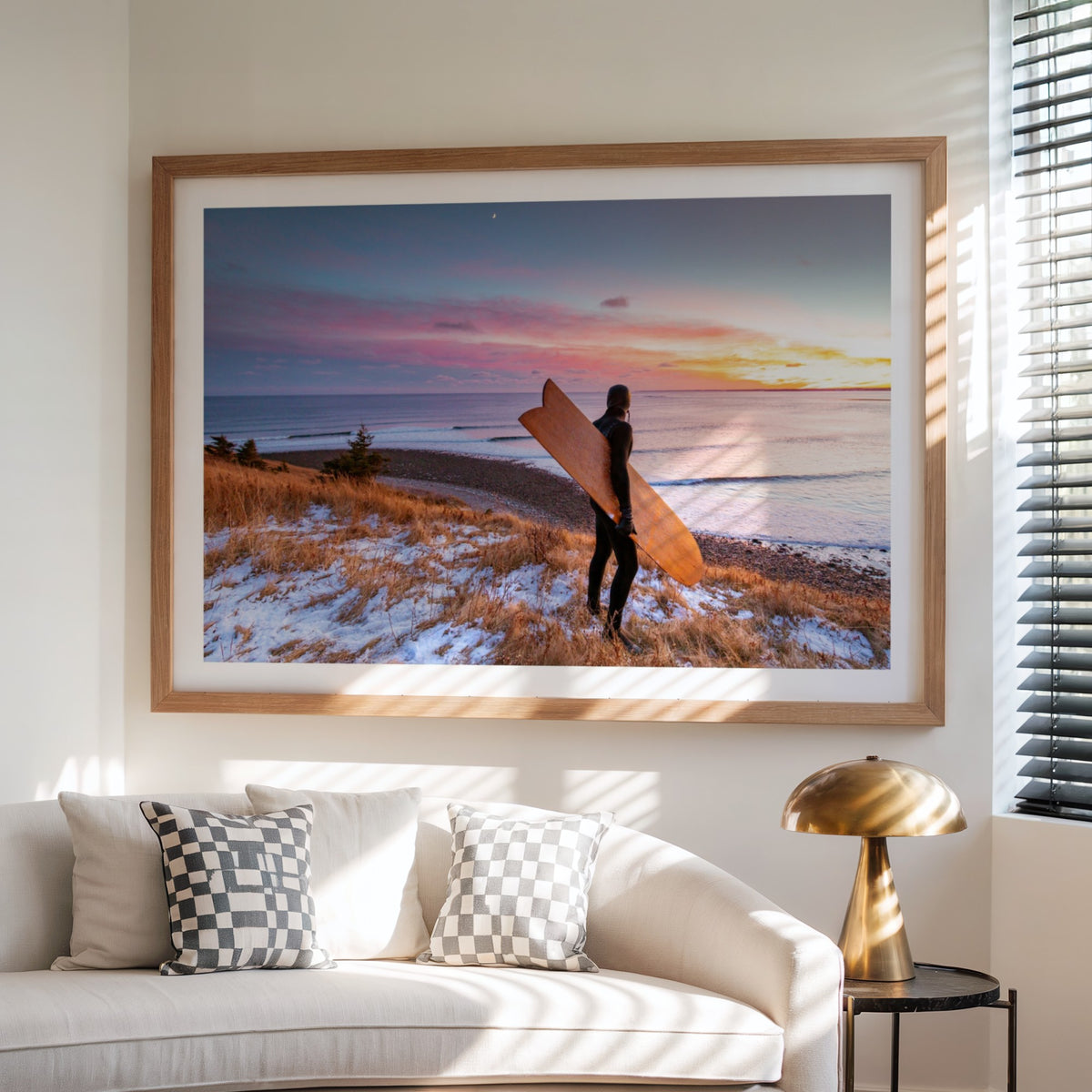 Snow and Sunrise winter surf photography print by Adam Cornick framed above a white sofa